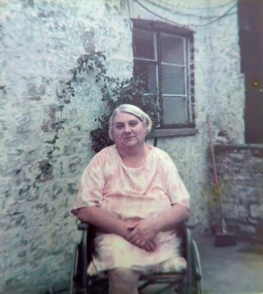 Mary (Nancy) Williams in her wheelchair in front of the whitewashed wall of Tŷ Mawr. A family photograph.